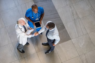 Medical device sales rep shaking hands with doctor.